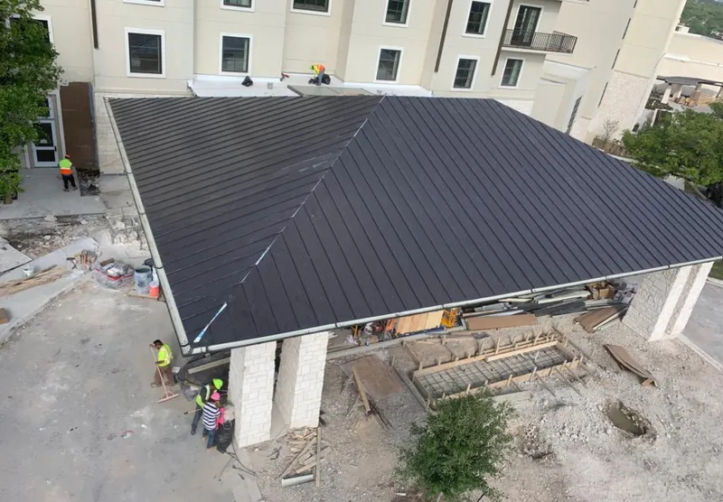 Metal roofing installation team working on a commercial building in Pulaski